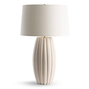 Beige table lamp with ribbed base and white shade on a white background
